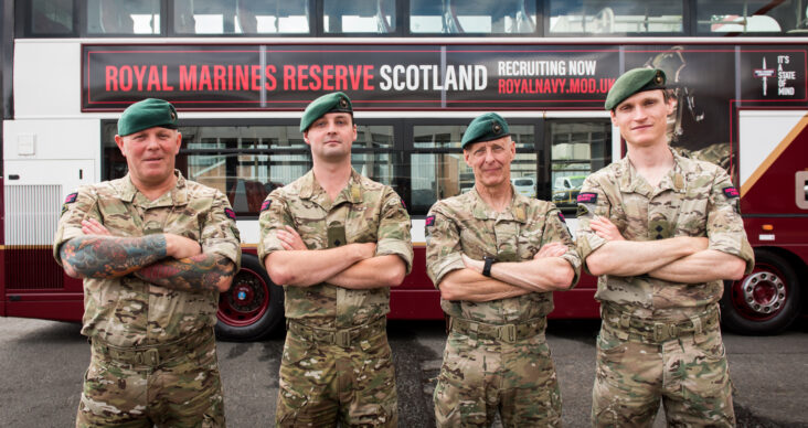 Royal Marines Reserve stand in front of bus
