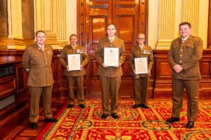 Five men in Army formal dress holding framed certificates