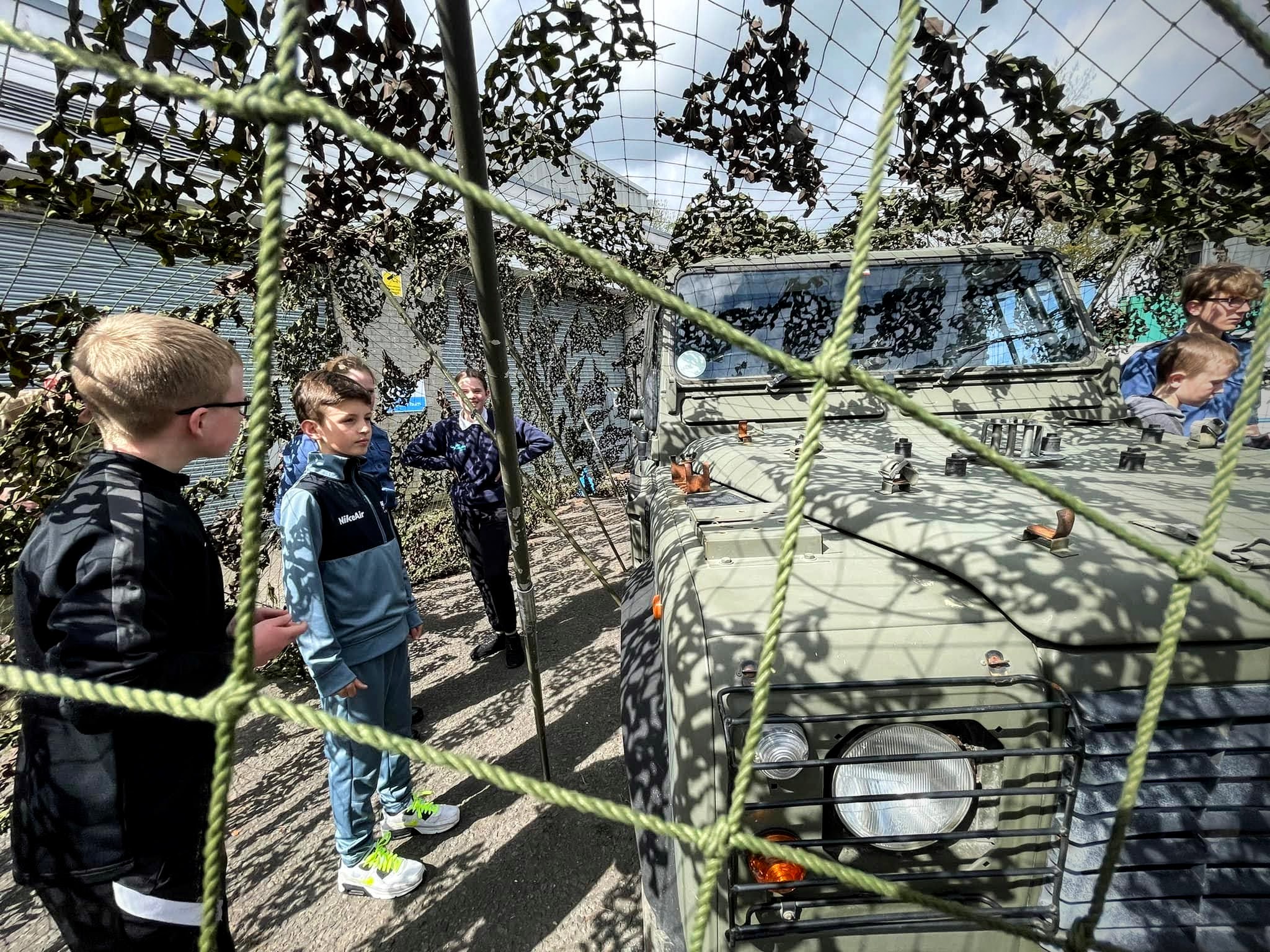 Sea Cadets look at vehicle in netting