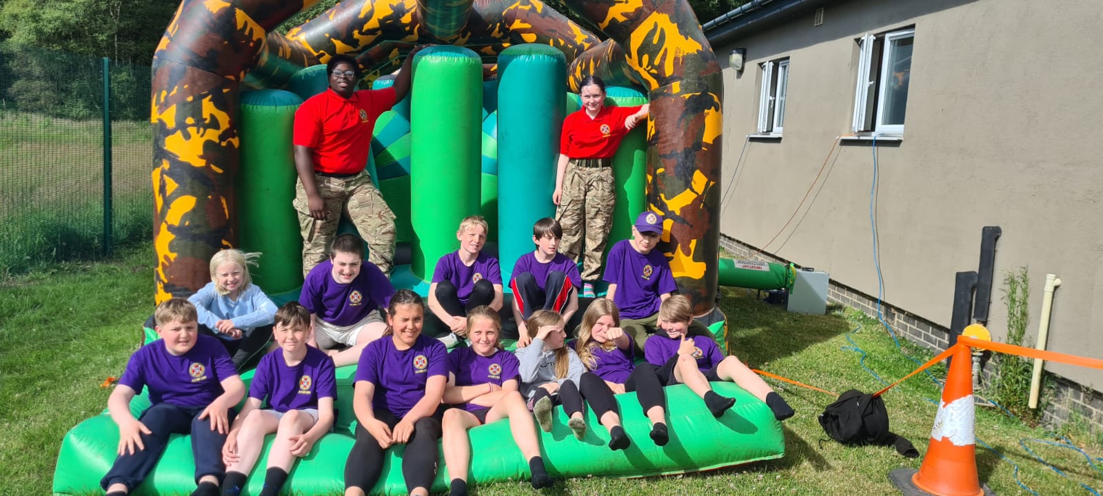 Cadets and Children sit on a bouncy castle
