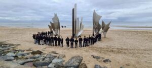 Cadets gathered around a memorial monument in Normandy