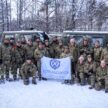 Royal Marine Reservists and employers posing in front of a BV amphibious vehicle with a Lowland RFCA banner