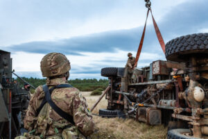 Image of a MAN SVR truck (support vehicle recovery), about to be used to upright an upturned donor heavy goods vehicle in field conditions by 2nd Battalion, Corps of The Royal Electrical and Mechanical Engineers or (2 Close Support Battalion REME).