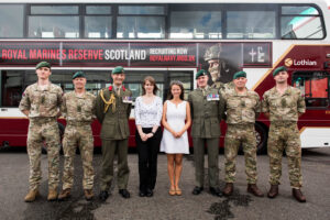 Lowland team and Royal Marines stand in front of the bus