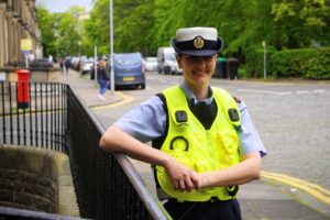 Gemma stands in RAF Police uniform by railings.