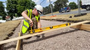 A Reservist working with a levelling tool while building a concrete path