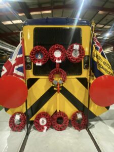 A train carriage at Brodie Engineering's Kilmarnock facility adorned on either side with flags and covered with poppy wreaths across the centre and base.