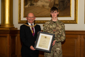 Cadet Lance Sergeant Rhaine Mertens receives his certificate as Lord-Lieutenant's Cadet from Councillor Robert Aldridge.