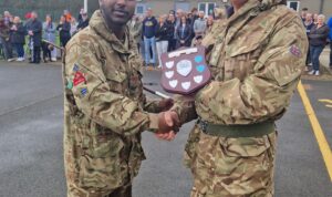 Trophy presentations taking place after the Lothian & Borders 3 star cadre, with a CFAV presenting a shield trophy to and shaking hands with a male Cadet