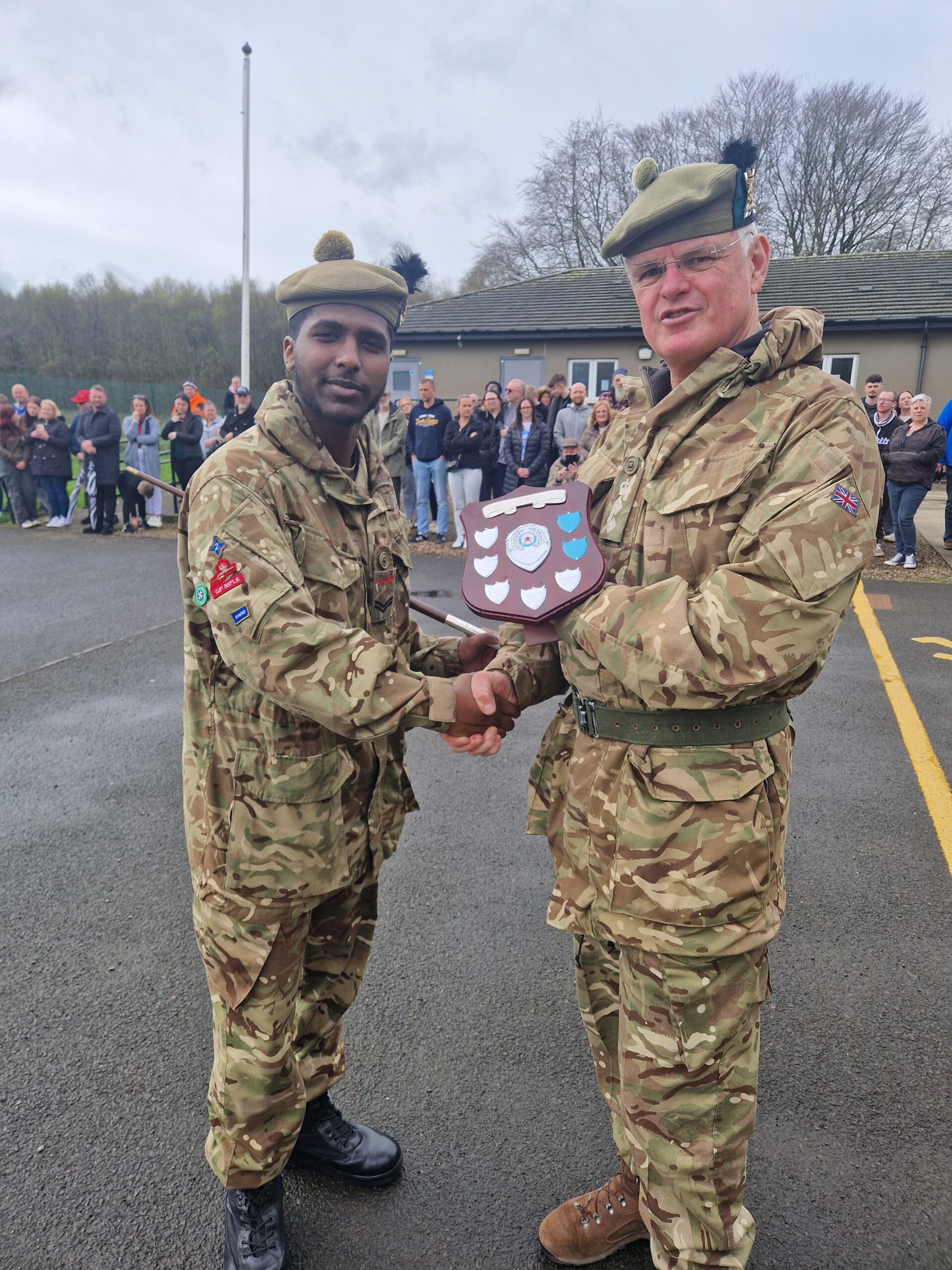 Trophy presentations taking place after the Lothian & Borders 3 star cadre, with a CFAV presenting a shield trophy to and shaking hands with a male Cadet