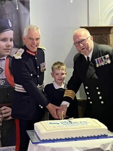 Lord-Lieutenant for East Lothian Roderick Urquhart, a junior Cadet and Commanding Officer Chris Gay cutting the celebration cake for the unit's 70th anniversary
