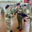 Major Andy Scott, Inspecting officer of 215 Multirole Medical Regiment, shakes hands with a female Cadet and presents the new detachment badge